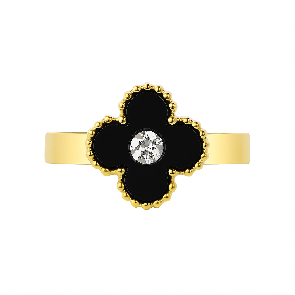Gold ring with a black clover-shaped setting and central gemstone on a white background